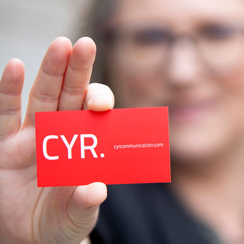 Veronique Cyr de CYR communication, carte professionnelle à la main